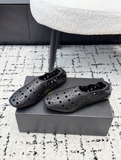 ALAIA 26S FLAT SLIP-ONS IN BLACK CALFSKIN WITH OPENWORK PATTERN