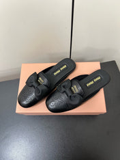 BOW MULES IN BLACK SHEEPSKIN