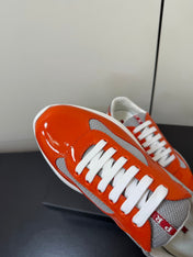 PRADA 26S SNEAKERS IN RED ORANGE PATENT CALFSKIN AND WHITE MESH