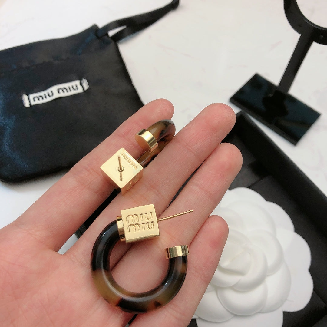 MIUMIU 26S TORTOISESHELL RESIN CURVED HOOP LOGO EARRINGS IN GOLD TONE METAL 615773