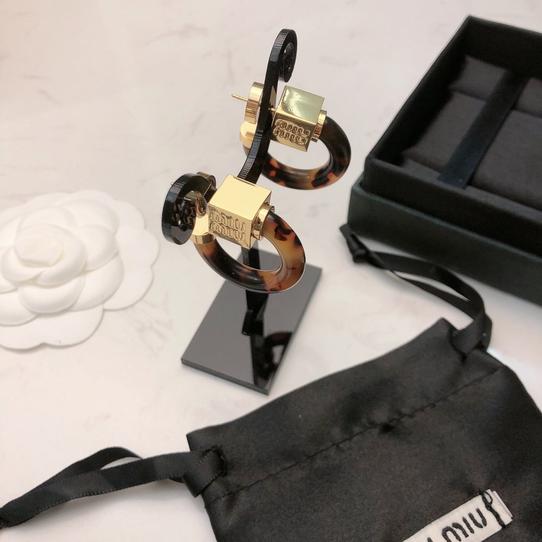 MIUMIU 26S TORTOISESHELL RESIN CURVED HOOP LOGO EARRINGS IN GOLD TONE METAL 615773