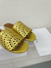 ALAIA VIENNE FLAT MULES IN GOLDEN LAMBSKIN