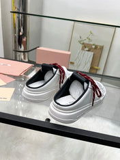 SNEAKER MULES IN BLACK AND WHITE CALFSKIN WHITE RED LACES